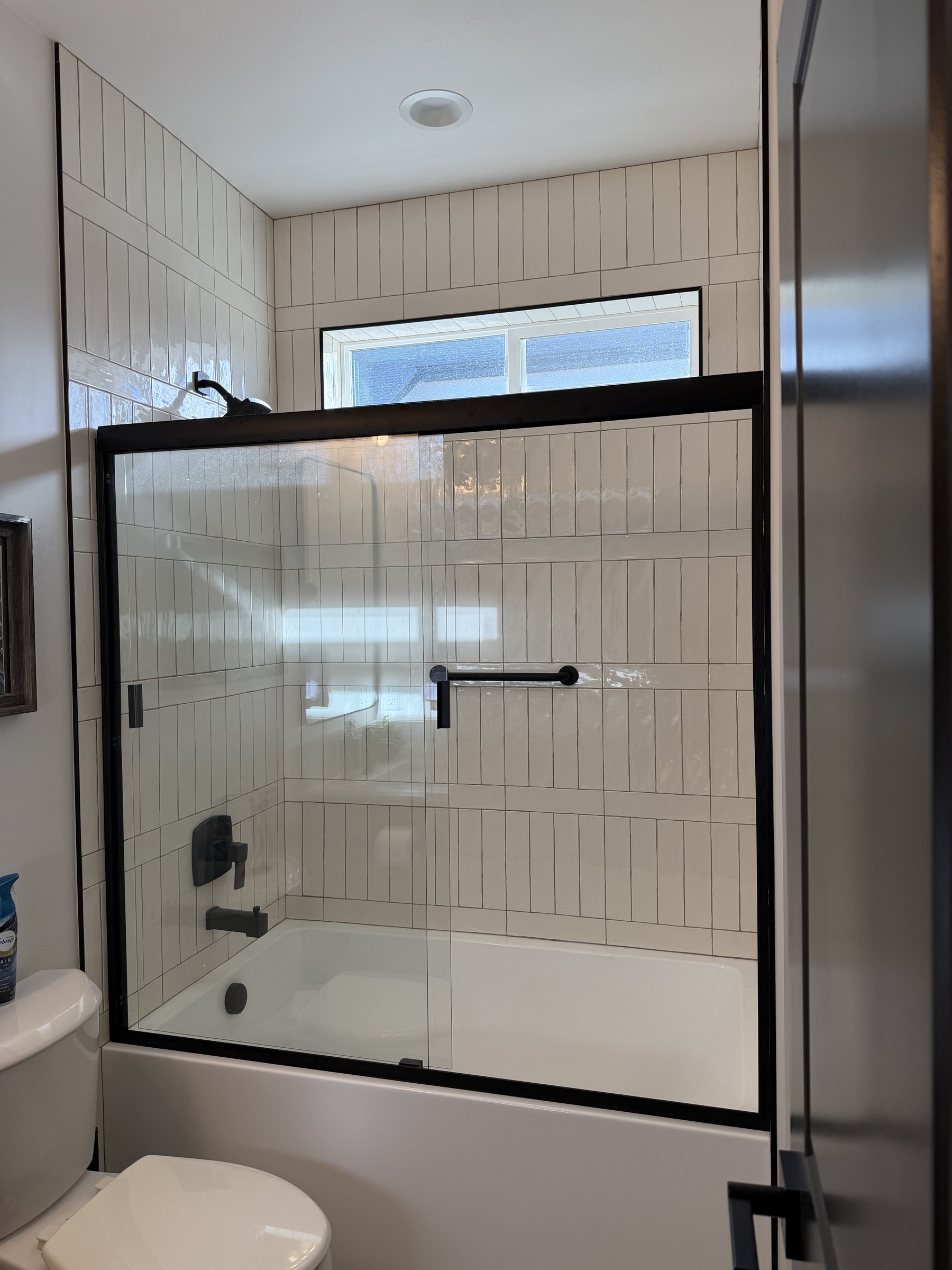 Walk-in shower with subway tile and glass enclosure
