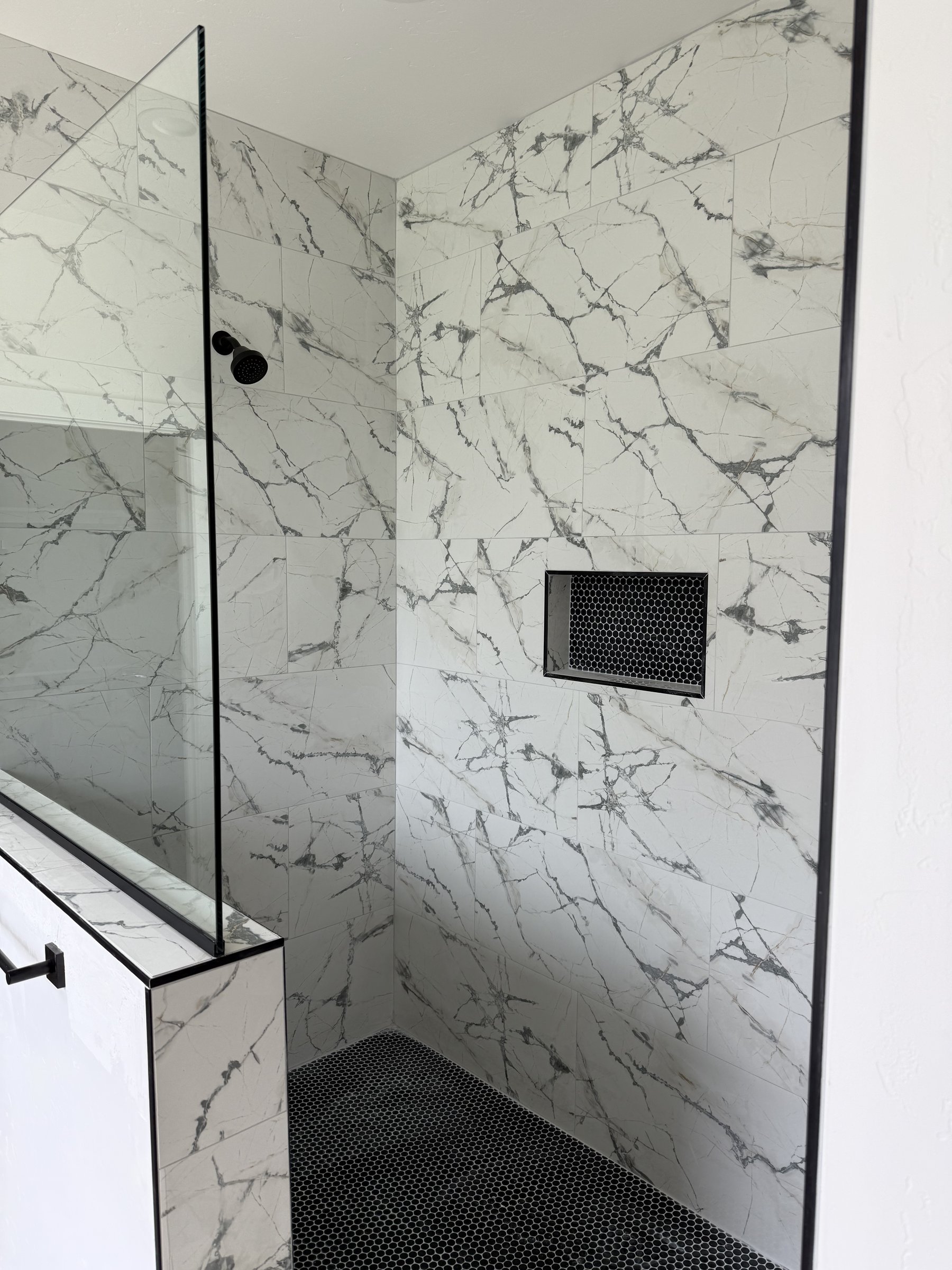 Marble shower with black hex inlay niche