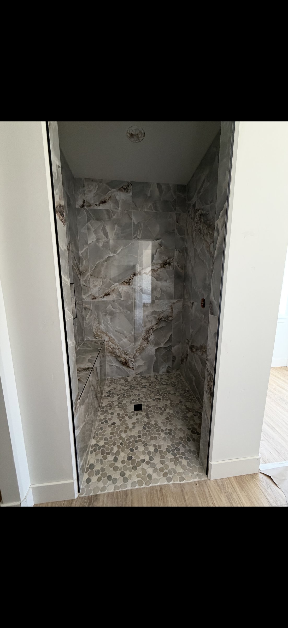 Onyx walk-in shower with pebble floor