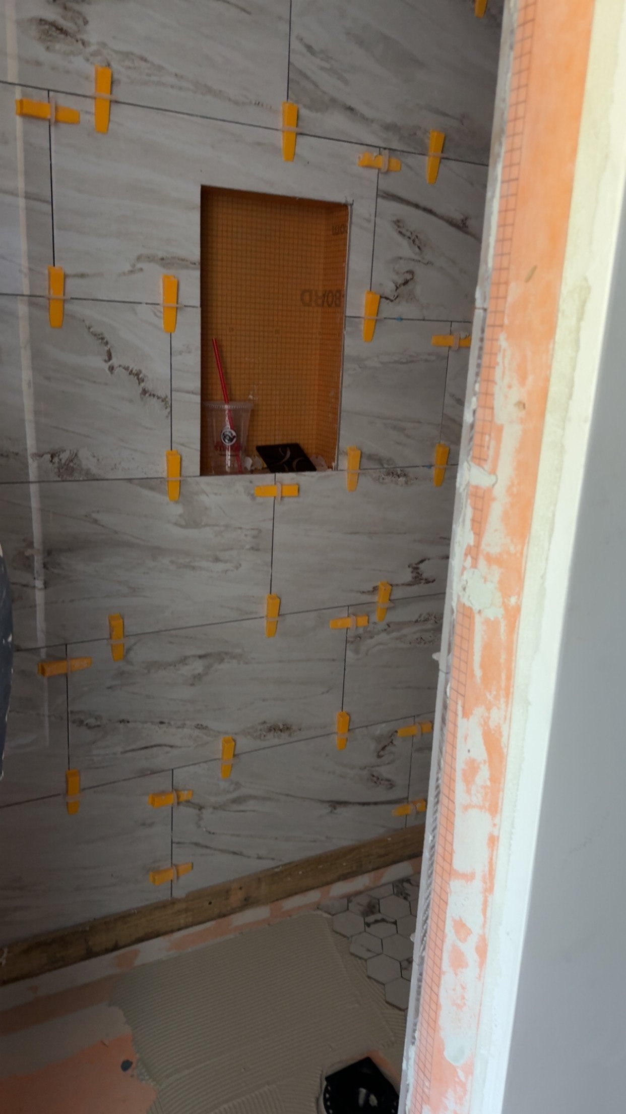 Shower wall tile install with leveling clips